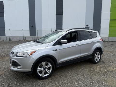 Silver 2014 Ford Escape parked with a sleek design featuring a compact SUV shape and alloy wheels