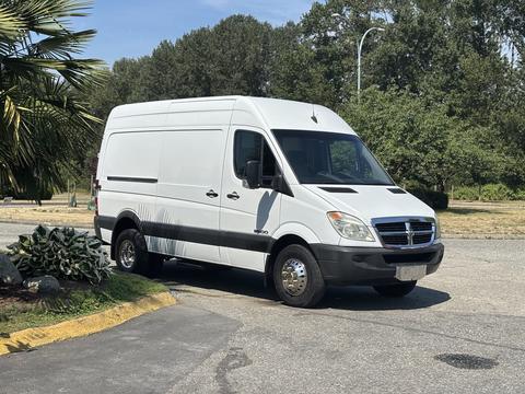 A white 2008 Dodge Sprinter Van parked with its side facing the viewer and a large cargo area visible