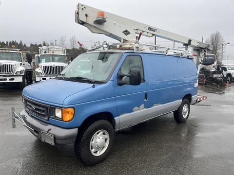 A blue 2006 Ford Econoline van with a raised bucket lift mounted on its roof and a ladder rack attached to the top