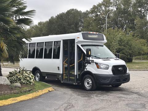 A 2021 Ford Transit-350 bus with a white exterior and large windows designed for public transport