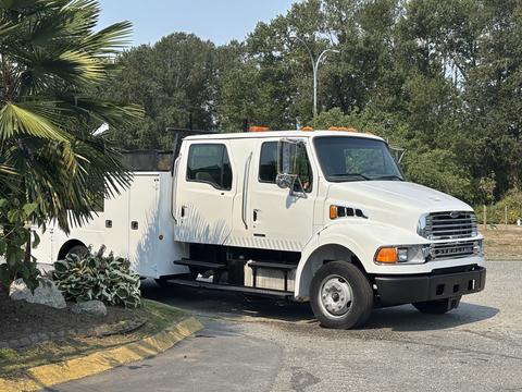 A 2006 Sterling Acterra truck with a white exterior featuring a double cab and side compartments for storage