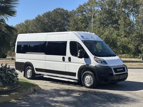 A 2020 RAM ProMaster 3500 van with a white exterior and large windows parked in a clear area
