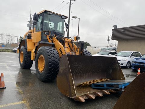 A yellow and black 2016 Hyundai HL940 wheel loader with a large front bucket positioned on a paved surface