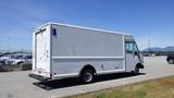 A white 2006 Ford Econoline van with a boxy shape and no visible branding parked in a lot