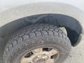 A close-up of a tire from a 2009 Ford F-150 showing a rugged tread pattern and a portion of the wheel rim