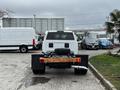 A white 2018 RAM 3500 truck viewed from the rear with an open flatbed and a spare tire mounted on the back