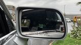 A side mirror of a 2013 Lincoln MKT showing a warning label about objects being closer than they appear