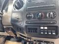 The interior dashboard of a 2010 Ford F-550 featuring various controls for climate and audio systems along with auxiliary switches
