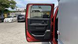 A red 2013 RAM 2500 truck with the driver's side door open showcasing the interior door panel and controls