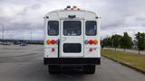 A white 2015 International PC105 bus viewed from the rear with multiple lights and a ladder on the back