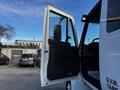 White 2013 International DuraStar 4300 truck with an open door showcasing the interior cabin and controls