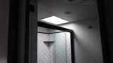 Interior view of a shower area in a 2021 Forest River Cedar Creek featuring glass doors and a tiled wall