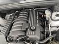 Engine compartment of a 2018 Jeep Grand Cherokee featuring a 6.4L HEMI engine with a black valve cover and various components visible