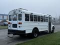 A 2016 International 4200 school bus with a white exterior and multiple windows on the side