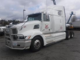 A 2022 Western Star Trucks 5700 semi-truck in white with a prominent grille and sleeper cab parked at a commercial location