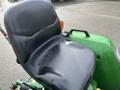 A black plastic seat of a 2003 John Deere 790 tractor showing signs of wear with small water droplets on the surface