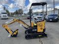 A yellow 2024 AGT Mini Excavator with a black rubber track and a small digging arm is parked in a lot among cars