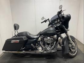 A 2013 Harley-Davidson FLHXI motorcycle featuring a black body sleek lines and a prominent front fairing with dual mirrors