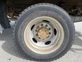 A close-up view of a 2010 Ford F-550 tire showing the alloy wheel and tire tread with visible wear and dirt on the surface