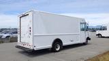 A white 2011 Ford Econoline cargo van with a sliding door and back entry, parked in a lot