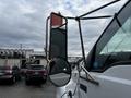 A 2008 Ford F-750 with a large side mirror reflecting its surroundings and a bright red accent on the mirror housing