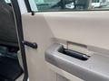 Interior door handle of a 2010 Ford F-550 with a beige plastic finish and a black lever for opening the door