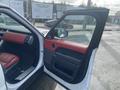 Interior view of a 2020 Land Rover Range Rover Sport with red leather seats and black trim showing the driver's side door open