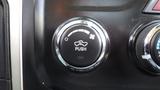 A round black push button with a car icon and a fan symbol above it indicating a feature in a 2014 RAM 5500 vehicle