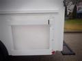 White cargo door on a 2003 Freightliner MT45 Chassis with a simple frame and a red indicator light at the bottom