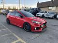 A red 2018 Ford Focus with a sporty design featuring a low profile, black wheels, and a custom front bumper and hood scoop