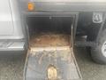 A rusted storage compartment with an open door mounted on the side of a 2015 Chevrolet Silverado 3500HD