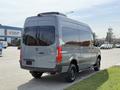A 2019 Mercedes-Benz Sprinter van in gray with large windows and a high roof, viewed from the rear and slightly to the side