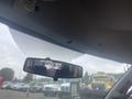 Interior view of a 2017 Chevrolet Express showing the rearview mirror with a reflective view of the seats and a glimpse of vehicles behind