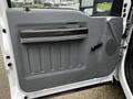 The interior door panel of a 2011 Ford F-250 SD featuring a handle a window crank and a textured design