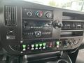 Interior dashboard of a 2018 Chevrolet Express featuring climate controls audio system and various switches and buttons for vehicle functions