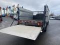 A 2008 Dodge Ram 5500 with a flatbed and a loading ramp lowered at the rear