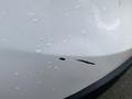 A 2016 Mazda CX-5 with a noticeable scratch on the rear bumper accompanied by small water droplets on the surface