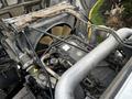 Engine compartment of a 2011 Western Star Trucks 4900 showcasing the cooling fan and various engine components including pipes and cables