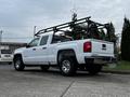 A 2018 GMC Sierra 1500 pickup truck with a white exterior and a black ladder rack on the bed