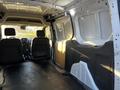 Interior view of a 2022 Ford Transit Connect showing two front seats and a spacious cargo area with a flat floor and side panels