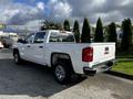 A 2017 GMC Sierra 1500 pickup truck with a white exterior and chrome accents parked on a concrete surface