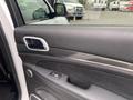 Interior view of a 2018 Jeep Grand Cherokee door panel featuring a black leather finish with carbon fiber accents and power window controls