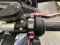 Close-up of the handlebar controls on a 2013 BMW K1600GTL featuring buttons for mode selection and a stop function with a clutch lever in red