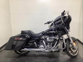 A black 2020 Harley-Davidson FLHX with a low profile seat chrome accents and a large front fairing displaying speakers and instruments