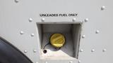 Fuel cap opening labeled Unleaded Fuel Only with a yellow cap visible inside the compartment