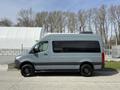 A 2019 Mercedes-Benz Sprinter van in a muted gray color with a sleek design and large windows parked on a driveway