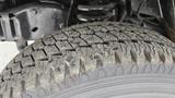 A close-up of a worn tire from a 2006 Ford Econoline showing visible tread patterns and wear on the rubber surface