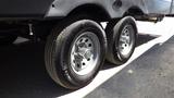 Close-up of two wheels on a 2022 Aspen Trail trailer showcasing silver rims and black tires