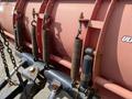 A close-up view of the suspension springs and hydraulic system of a snowplow attached to a 2010 Ford F-550 truck