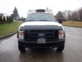 A 2009 Ford F-450 Super Duty truck facing forward with a silver body and a black grille featuring the Ford logo